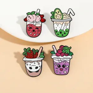 Nahaufnahme von vier süßen Frucht-Milchtee-Emaille-Pins mit Pfirsich- und Avocado-Motiven