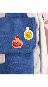 Detailed view of creative enamel pins featuring maple leaf and sun designs on a blue backpack