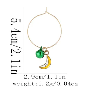 Detail view of gold hoop earrings with banana and bell charms showing 5.4cm diameter
