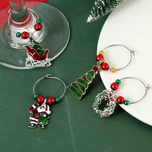 Set of 4 Christmas wine glass charms with Santa, tree and beads on green background