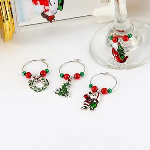 Close-up of four Christmas wine glass charms with colorful enamel holiday pendants
