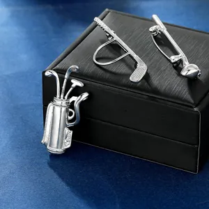 Detail view of silver golf club and bag brooches with diamonds on a premium gift box