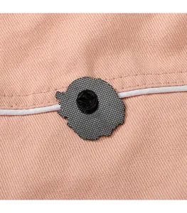 Dettaglio del retro della spilla nera con chiusura in gomma su tessuto rosa