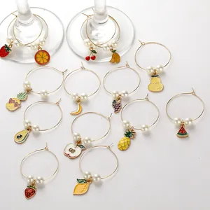 Close-up of fruit-themed wine glass charms with alloy pendants and pearls on white