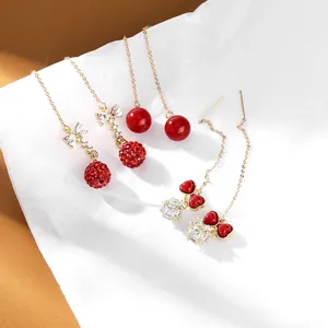 Tre paia di eleganti orecchini pendenti lunghi rossi e dorati con fiocchi e cuori