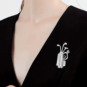 Silver golf bag brooch with cubic zirconia crystals worn on a black suit lapel