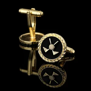 Macro shot of gold-plated golf theme cufflinks with crossed clubs on black background