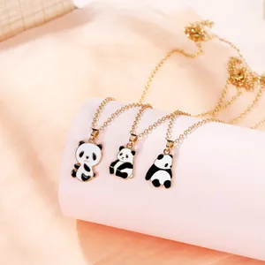 Detailed view of three panda enamel pendants with sitting and lying poses on gold chains
