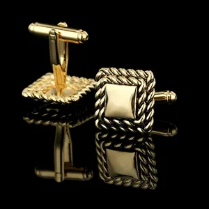 Close-up of square gold cufflinks with polished center and twisted rope border