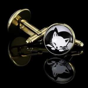 Detailed view of round vintage cufflinks with a sleeping cat design on a black background