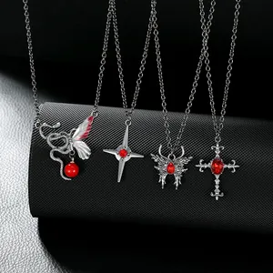 Detailed close-up of gothic silver snake, butterfly, and cross pendants with red stones