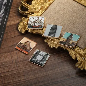 Détail de cinq pin's émaillés représentant des monuments mondiaux sur table en bois