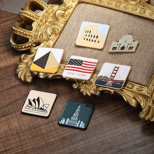 Détails de broches en émail représentant des monuments mondiaux dans un cadre doré
