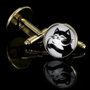 Macro shot of vintage bronze cat cufflinks with cute hand-drawn cat motif on black background