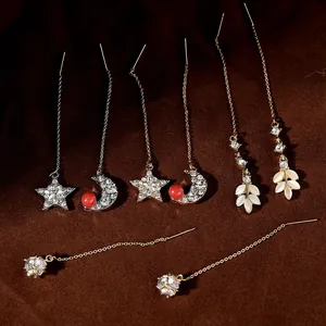 Dettaglio di orecchini pendenti con perle e zirconi e design elegante a catena lunga