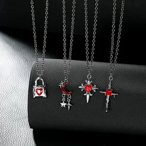 Macro detail of gothic style silver necklaces with red gemstone pendants on mesh display