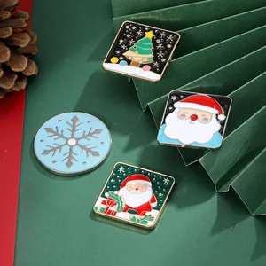 Detailansicht von vier festlichen Weihnachtsemaille-Pins auf dekorativem grünem Grund