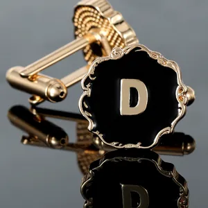 Macro detail of luxury round cufflink featuring golden letter D and black enamel finish
