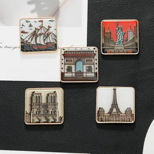 Détail de cinq badges de voyage vintage en métal avec des monuments comme la Tour Eiffel
