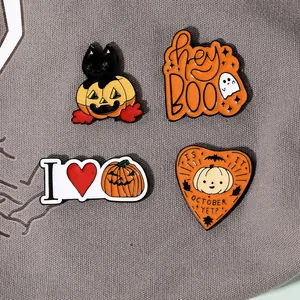 Detail of four Halloween enamel pin badges including black cat, ghost and pumpkin motifs