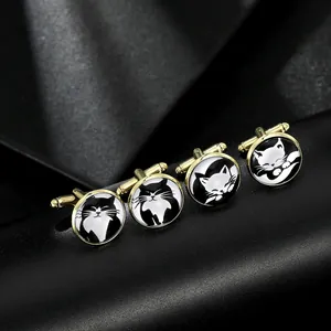 Macro shot of gold-plated round cufflinks featuring cute black and white cat illustrations