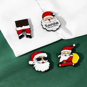 Detailaufnahme süßer Weihnachtsmann-Emaille-Anstecknadeln auf einem weißen Hemd