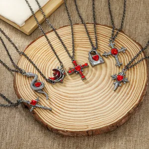 Gothic necklace set featuring silver snakes and red crystals on rustic wood display