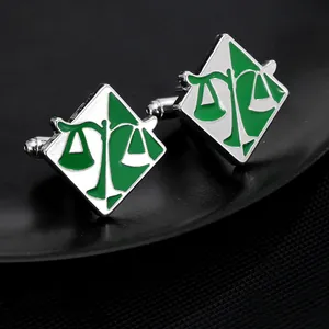 Detail of round silver cufflinks with green enamel scales of justice for men's shirts