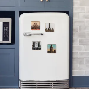 Détail de magnets 3D avec le Louvre et la Tour Eiffel sur un réfrigérateur blanc