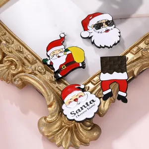 Detailansicht von vier Weihnachts-Emaille-Pins mit Weihnachtsmann-Motiven und Schriftzug
