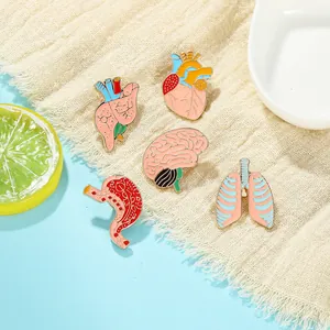 Detailed view of colorful human organ enamel pins including heart and brain on fabric