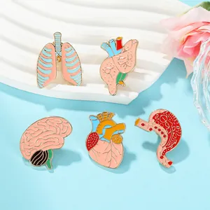 Detail view of five creative anatomical organ enamel pins in vibrant colors