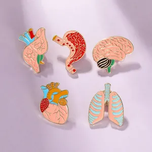 Set of five colorful organ enamel pins including heart and brain on purple background