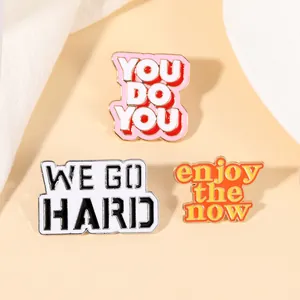 Tre spille in smalto con frasi You Do You e We Go Hard per decorazione vestiti e zaini