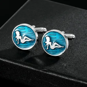 Detailed macro view of silver-tone cufflinks with blue enamel and female silhouette inlay