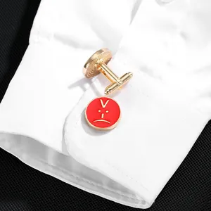 Elegant gold round cufflinks with red enamel finish and V-symbol on white dress shirt