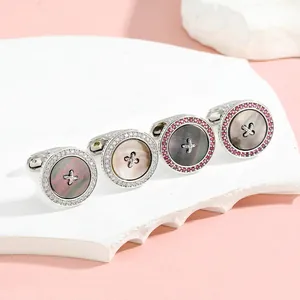 Macro detail of round mother-of-pearl cufflinks with crystal halo on stone display