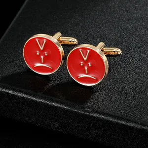 Macro detail of round red enamel cufflinks with gold base and sad face design