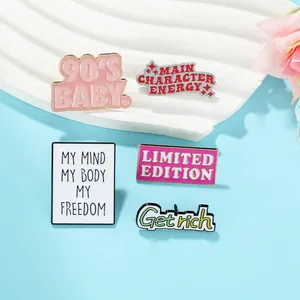 Macro shot of colorful enamel pins with motivational quotes on a wavy white tray