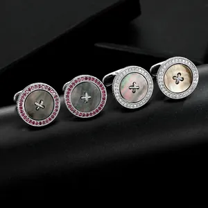 Close-up of circular button cufflinks with mother of pearl inlay and crystal accents