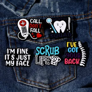 Detailansicht von fünf medizinischen Emaille-Pins an einer blauen Jeansjackentasche