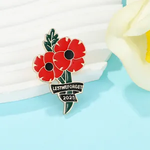 Detail of red poppy 2025 enamel brooch with Lest We Forget text on white display