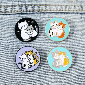Lot de quatre broches rondes en émail représentant des chats s'enlaçant sur tissu denim