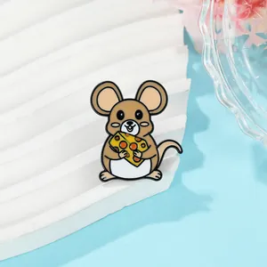 Détail d'un pin's mignon en émail représentant une souris marron tenant du fromage jaune