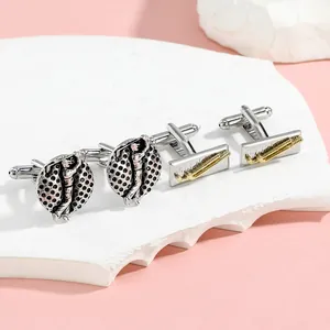 Detail shot of vintage silver golf cufflinks and golden club design on stone display