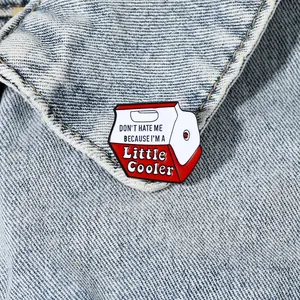 Funny cooler-shaped enamel pin with quote on denim jacket collar, creative badge accessory