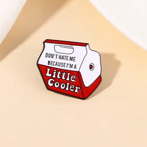 Detailed close-up of a red cooler enamel pin with Don't Hate Me phrase on light background