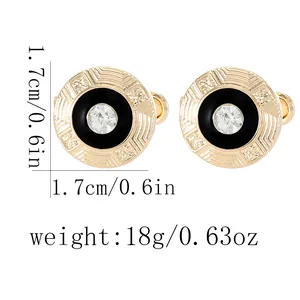 Detail showing round gold cufflinks with black enamel and central crystal inlay