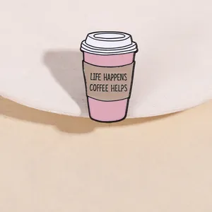 Close-up of pink coffee cup enamel pin with Life Happens Coffee Helps inscription