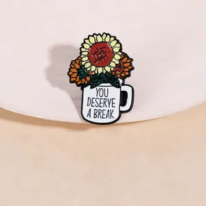 Detail of flower bouquet enamel pin in white mug with You Deserve A Break text